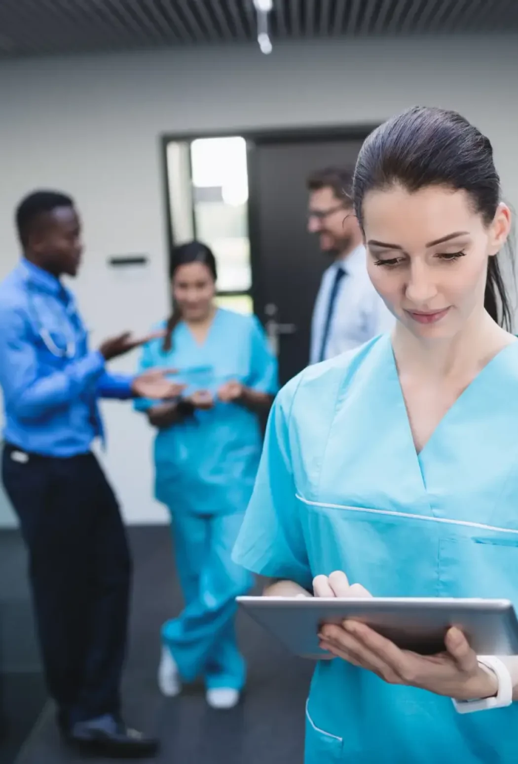 nurse using digital tablet hospital corridor